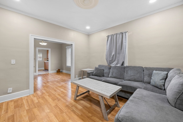 living room with light wood-type flooring, crown molding, baseboards, and recessed lighting