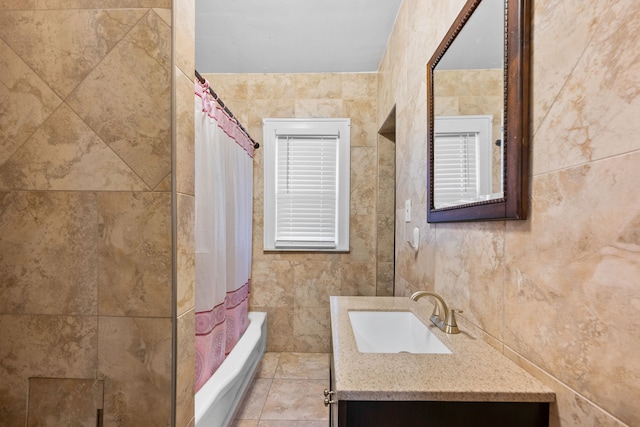 full bathroom with shower / bath combo with shower curtain, vanity, and tile walls