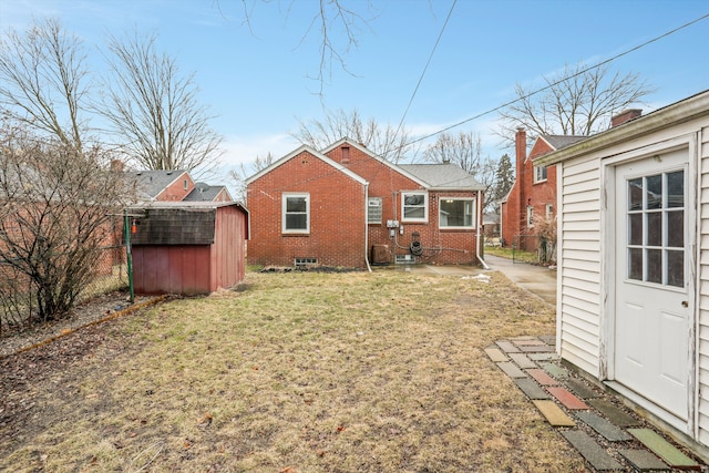 back of property featuring a yard, an outbuilding, a shed, and fence