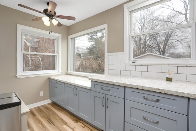 kitchen with a wealth of natural light, backsplash, and gray cabinetry