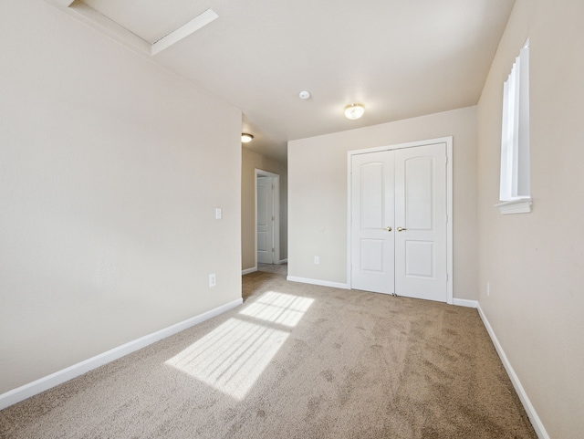 unfurnished bedroom featuring a closet, baseboards, and carpet flooring