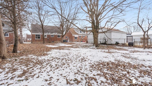 yard covered in snow with a garage and fence