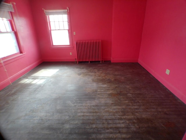 empty room featuring radiator heating unit and dark wood finished floors