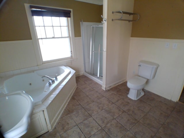 full bath with a wainscoted wall, a stall shower, a whirlpool tub, and toilet