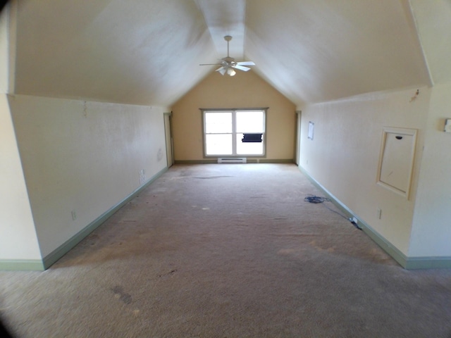 additional living space with light carpet, vaulted ceiling, and baseboards