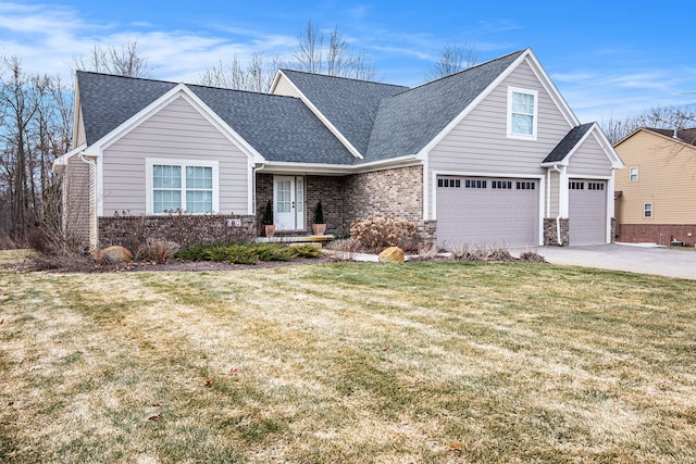 view of front of property with driveway, roof with shingles, an attached garage, a front lawn, and brick siding