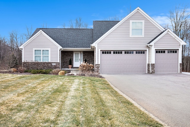 view of front of home with a front yard, brick siding, driveway, and roof with shingles