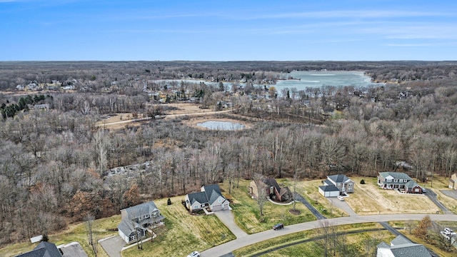 aerial view featuring a forest view and a water view