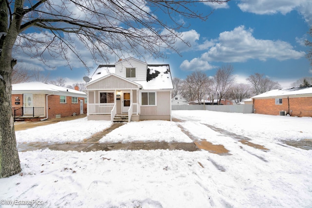 bungalow-style home with a porch and a detached garage