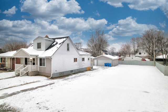 exterior space with an outbuilding, a porch, a detached garage, and fence