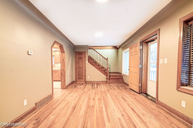 entrance foyer with light wood-style floors, visible vents, baseboards, and stairs