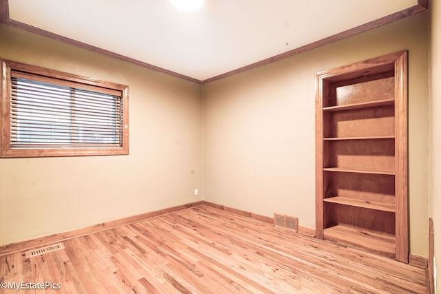 unfurnished room featuring visible vents, crown molding, baseboards, and wood finished floors