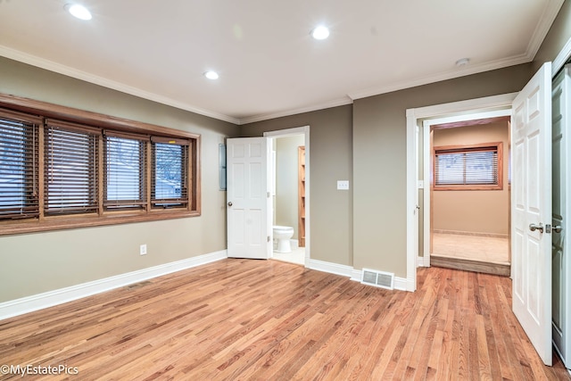 unfurnished bedroom with ornamental molding, visible vents, light wood-style flooring, and baseboards