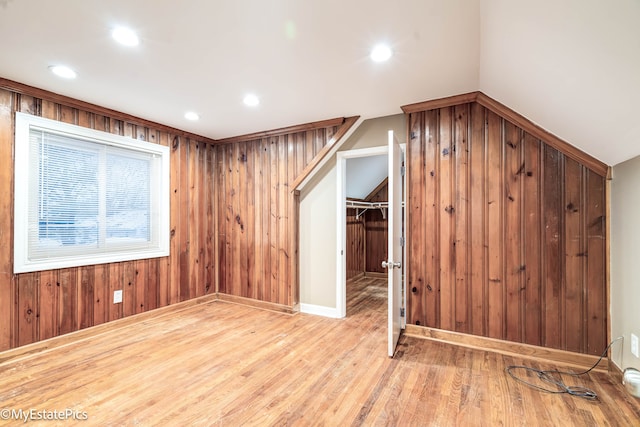 additional living space with wood walls, wood finished floors, and recessed lighting