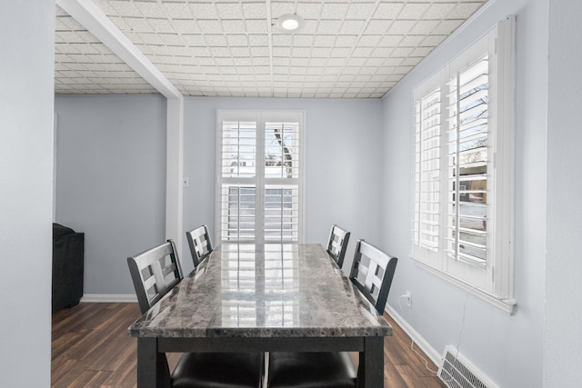 dining space with dark wood finished floors, visible vents, and baseboards