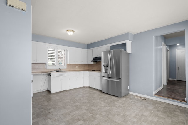 kitchen featuring under cabinet range hood, visible vents, white cabinetry, stainless steel fridge with ice dispenser, and decorative backsplash