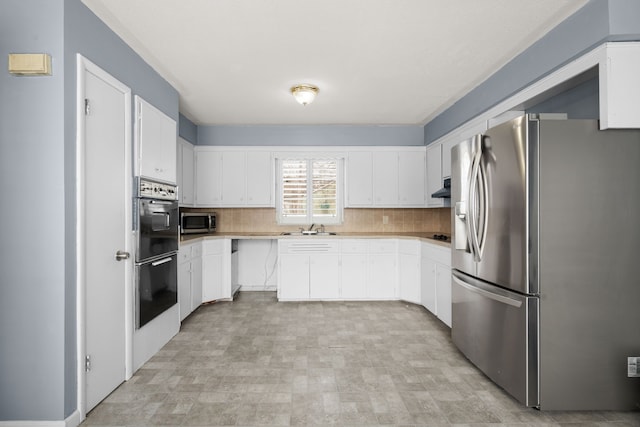 kitchen with decorative backsplash, stainless steel appliances, light countertops, white cabinetry, and a sink