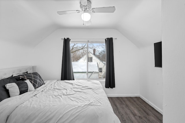 bedroom featuring dark wood-type flooring, vaulted ceiling, baseboards, and a ceiling fan