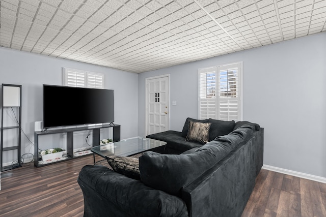 living area with baseboards and dark wood finished floors