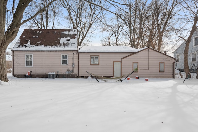 snow covered rear of property featuring cooling unit