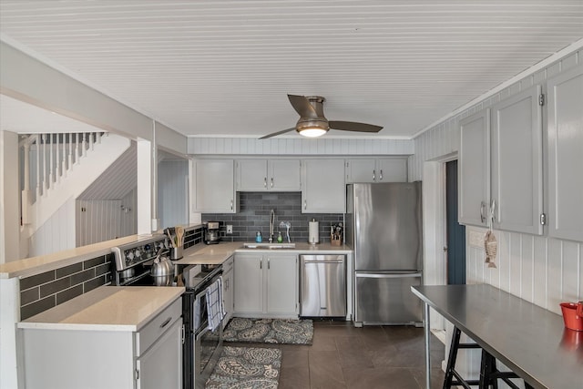 kitchen with light countertops, backsplash, appliances with stainless steel finishes, and a sink