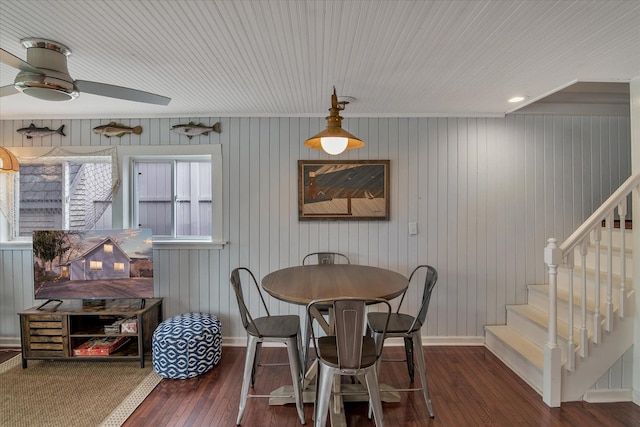 dining room featuring baseboards, stairs, ceiling fan, and hardwood / wood-style flooring