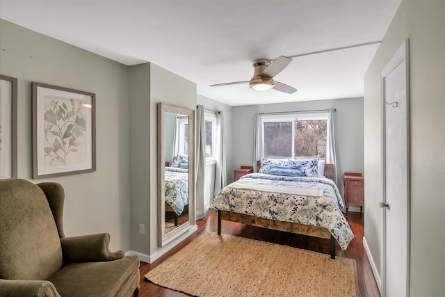 bedroom featuring a ceiling fan, wood finished floors, and baseboards