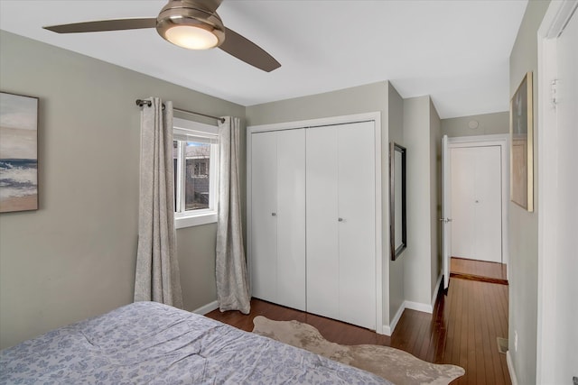 bedroom featuring a closet, a ceiling fan, baseboards, and wood finished floors