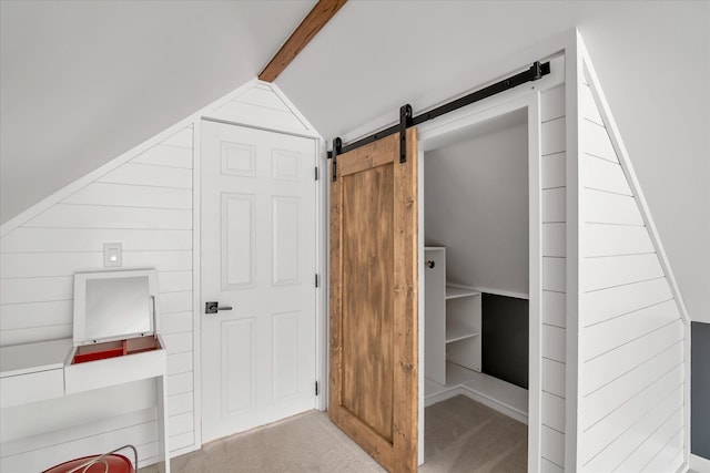 additional living space featuring a barn door, lofted ceiling, and carpet