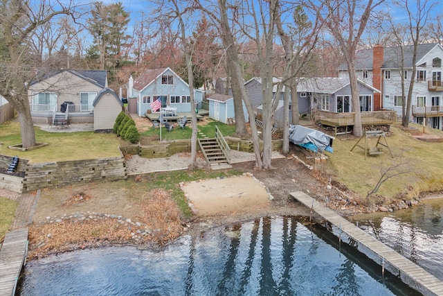 view of yard featuring a residential view, driveway, stairs, and a water view