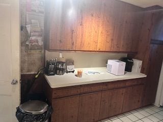 kitchen featuring brown cabinetry, light countertops, and light tile patterned flooring