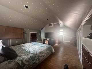 bedroom featuring lofted ceiling and wood finished floors