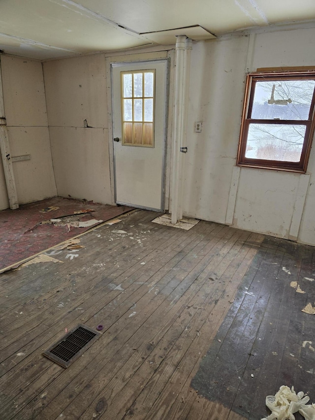 unfurnished room featuring visible vents and dark wood-style flooring