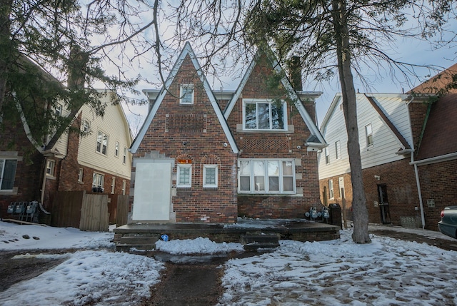 view of front facade with brick siding and fence