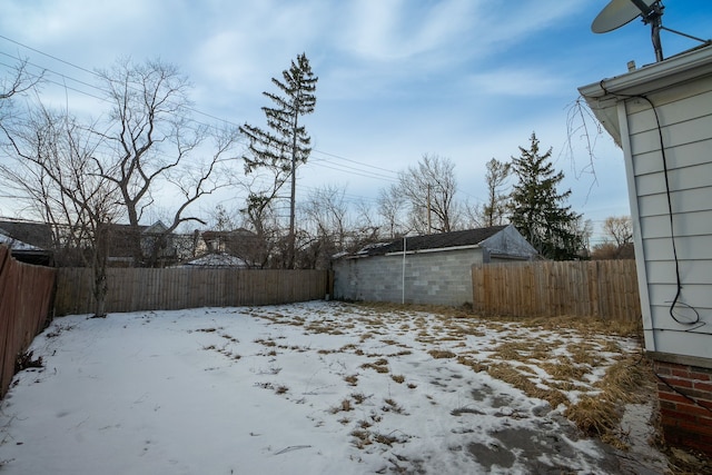 snowy yard featuring fence