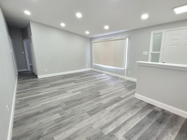 unfurnished room with recessed lighting, light wood-style flooring, and baseboards