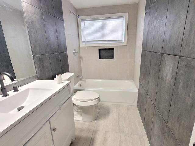 bathroom featuring toilet, bathtub / shower combination, tile walls, and vanity