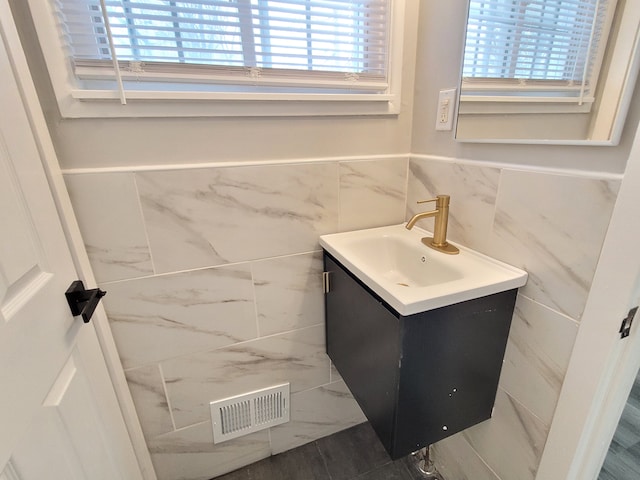 bathroom with wainscoting, plenty of natural light, visible vents, and vanity