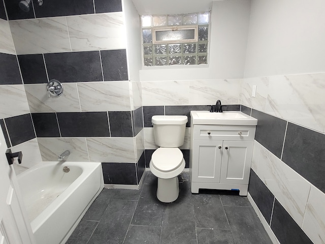 bathroom with toilet, vanity, and tile walls