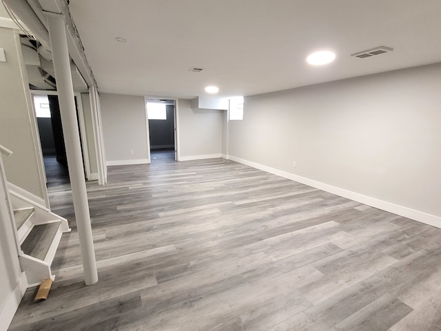 basement featuring stairway, light wood-type flooring, and baseboards