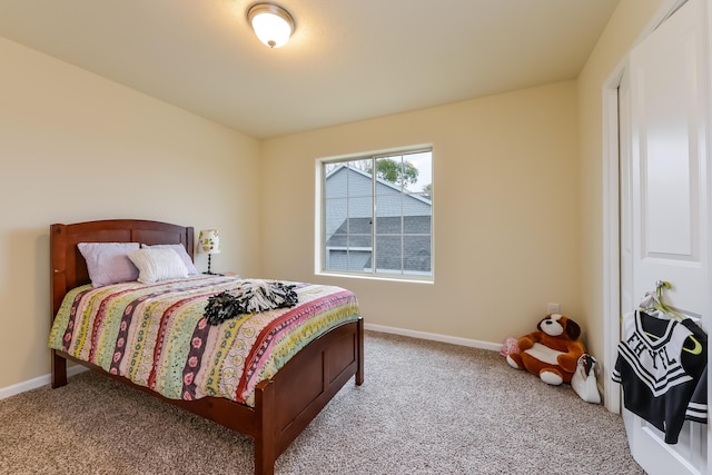 bedroom featuring light carpet and baseboards