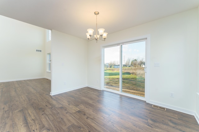 5124 Huggins Rd, Michigan Center, MI 49254 - empty room featuring dark wood-style floors, baseboards, visible vents, and a notable chandelier