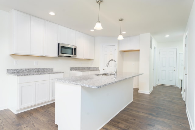 5124 Huggins Rd, Michigan Center, MI 49254 - kitchen featuring a kitchen island with sink, a sink, white cabinetry, stainless steel microwave, and decorative light fixtures