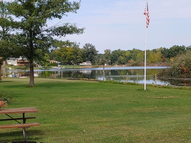 view of community featuring a lawn and a water view