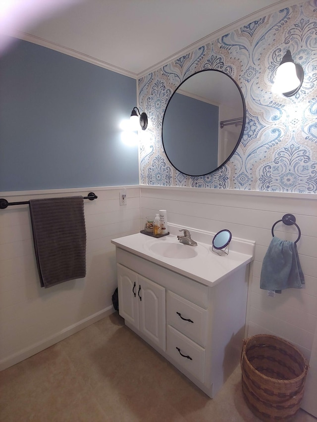 bathroom featuring a wainscoted wall, ornamental molding, and vanity
