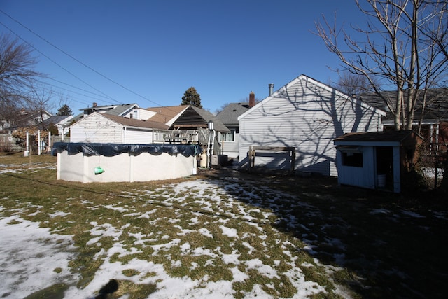 yard layered in snow featuring a covered pool