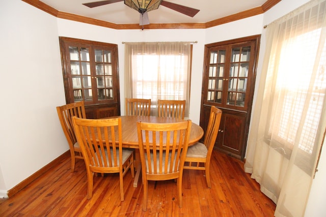 dining area with baseboards, wood finished floors, and crown molding