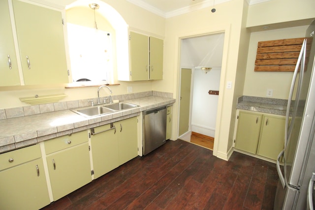 kitchen featuring stainless steel appliances, dark wood-type flooring, a sink, tile counters, and crown molding