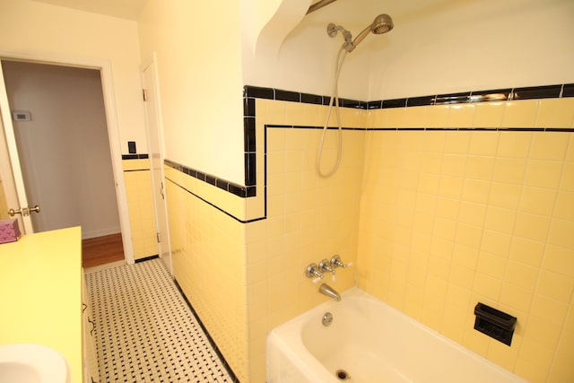 full bath featuring shower / washtub combination, wainscoting, and tile walls