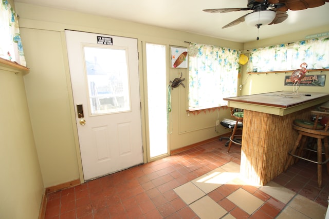 entryway featuring ceiling fan, a dry bar, and baseboards